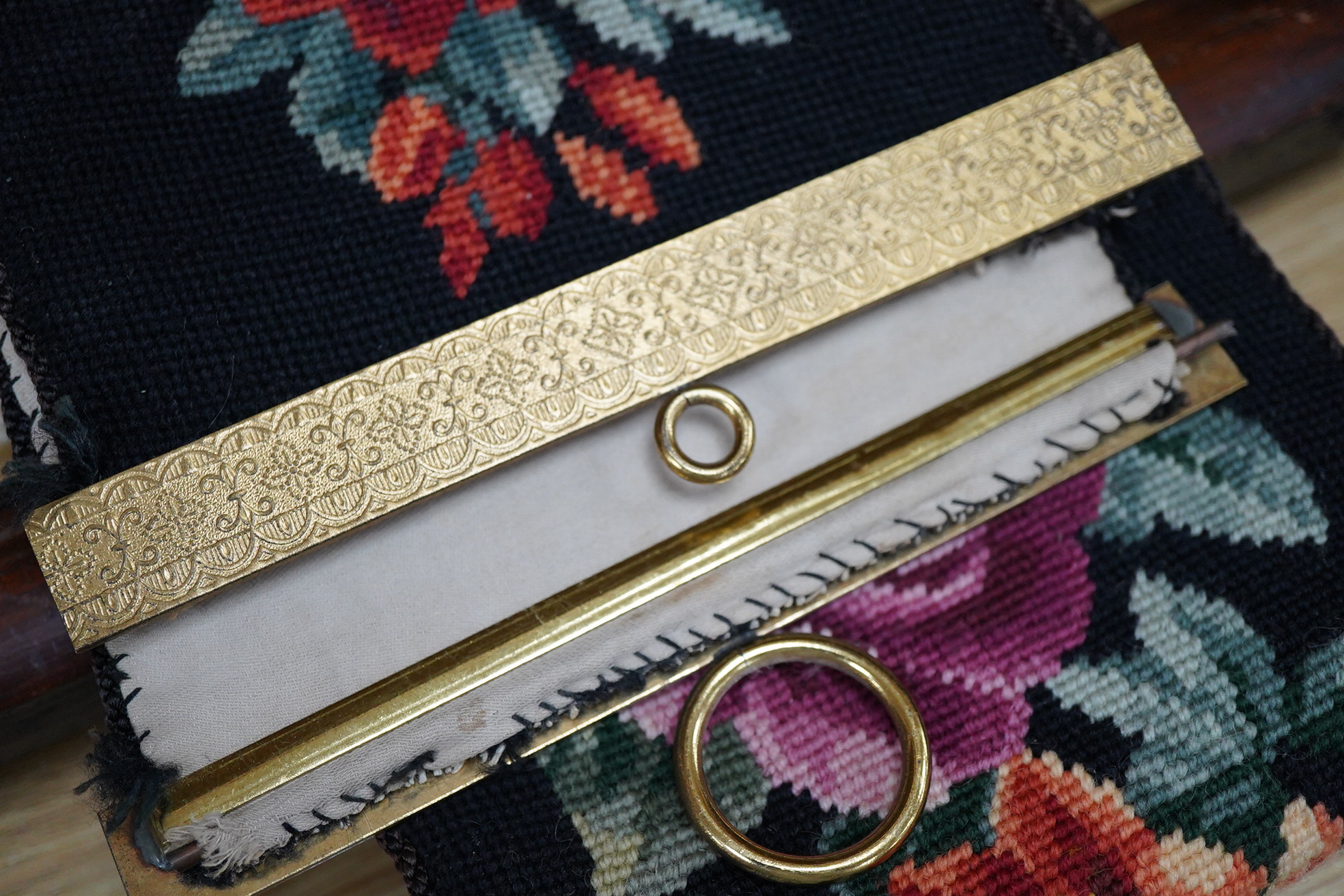 A framed 19th century woolwork embroidery of a bird, a floral wool bell pull with gilt mounts and a large maple frame